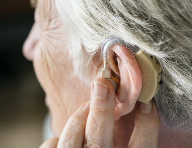 person wearing hearing aid to help hearing loss